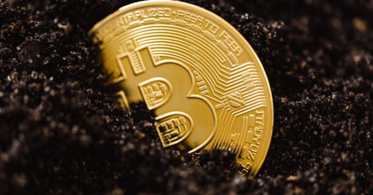 Assets - Close-up of a Bitcoin Coin Lying in Dirt on the Ground