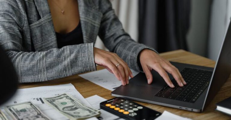 Profitability - A Woman in Plaid Blazer Using Her Laptop